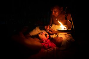 Theyyam make up under the oil lamp
